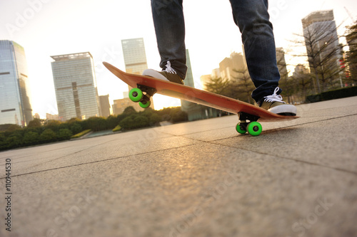 skateboarder legs skateboarding at sunrise city