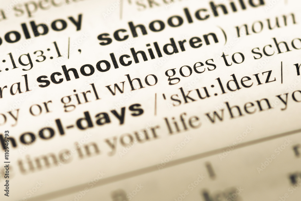 Close up of old English dictionary page with word schoolchildren Close up of old English dictionary page with word schoolchildren