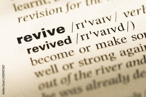 Close up of old English dictionary page with word revive