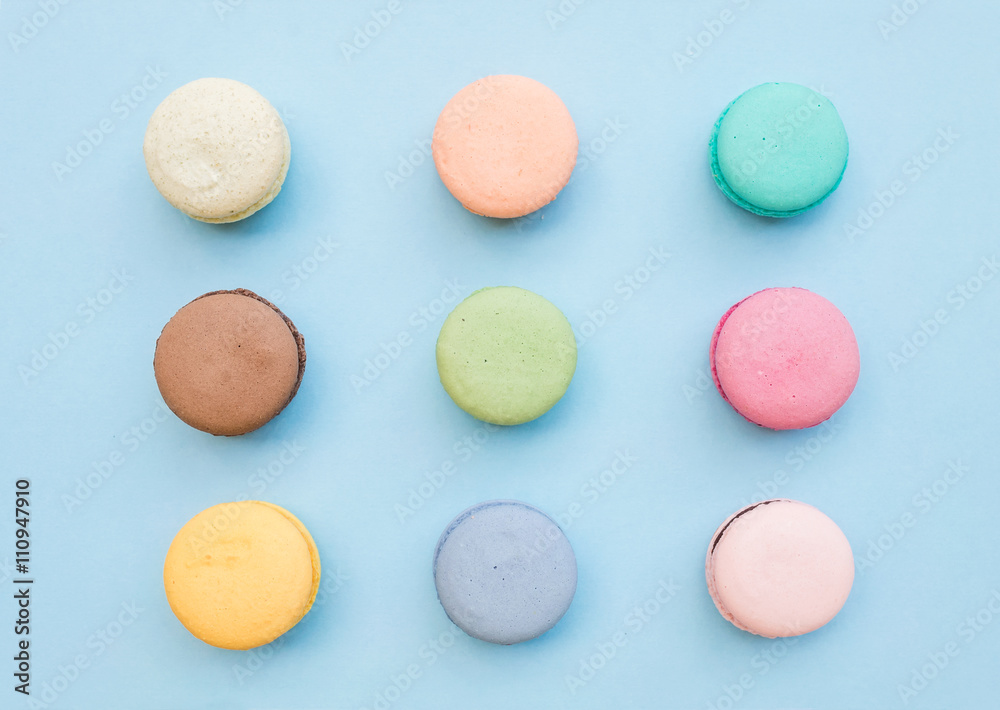 Sweet colorful French macaroon biscuits on pastel blue background Sweet colorful French macaroon biscuits on pastel blue background