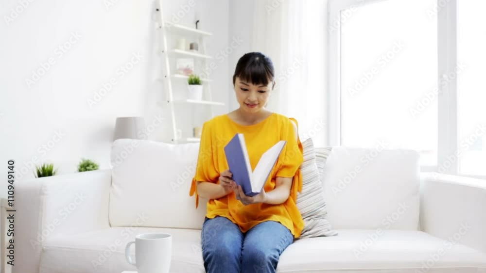 smiling young asian woman reading book at home smiling young asian woman reading book at home