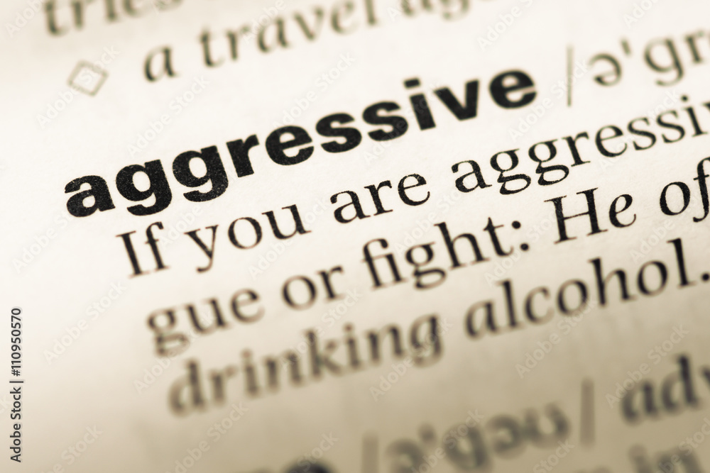 Close up of old English dictionary page with word aggressive Close up of old English dictionary page with word aggressive