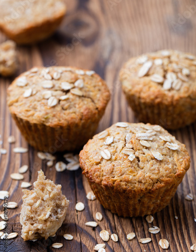Healthy vegan oat muffins, apple and banana cakes on a wooden background.