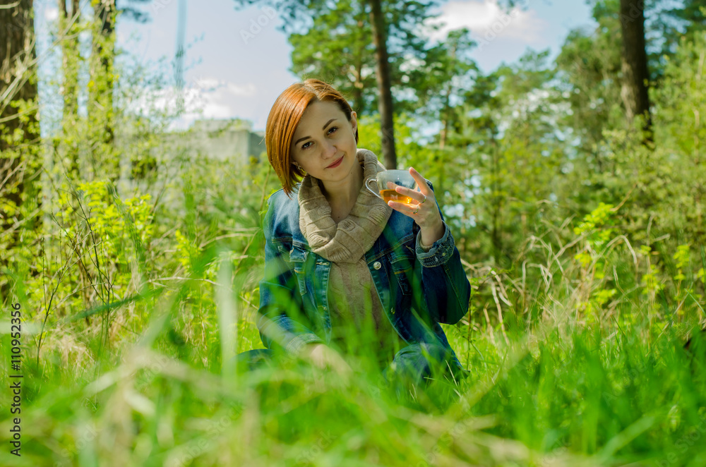 Beautiful girl and cup green tea in the forest Beautiful girl and cup green tea in the forest