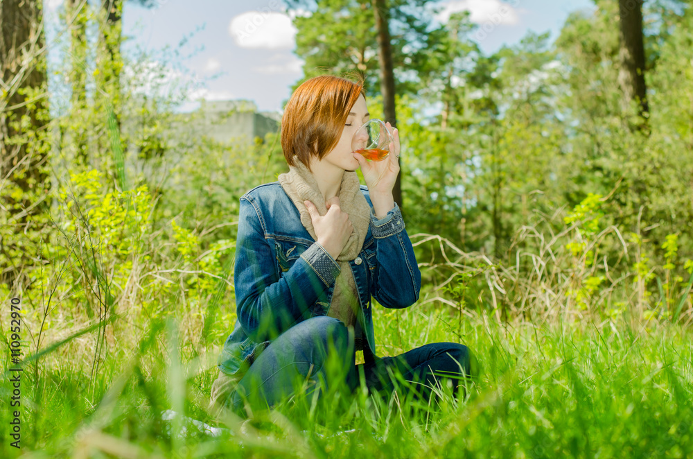 Beautiful girl and cup green tea in the forest Beautiful girl and cup green tea in the forest