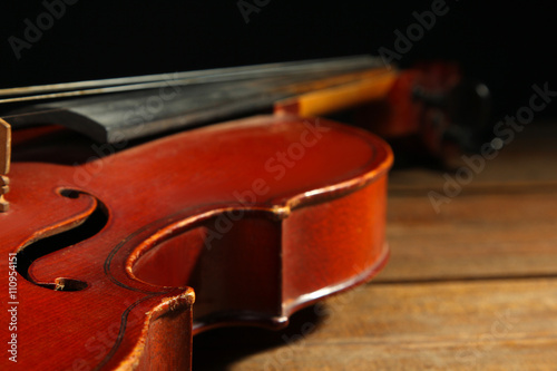violin on wooden brown background closeup