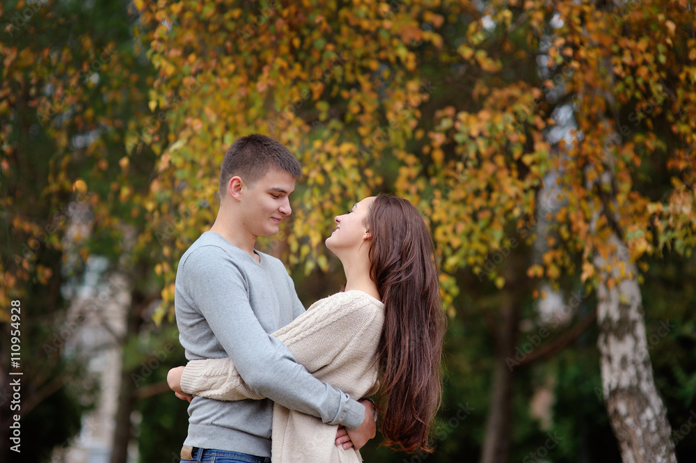 happy young couple embracing outdoor in the autumn park