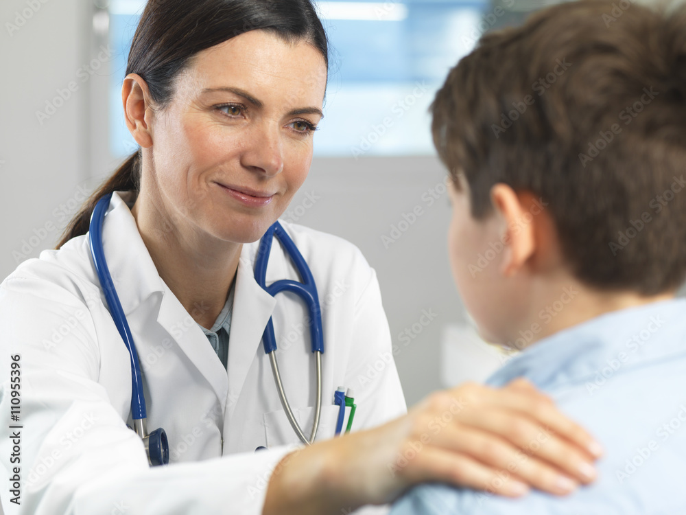 Doctor comforting young boy in clinic Doctor comforting young boy in clinic