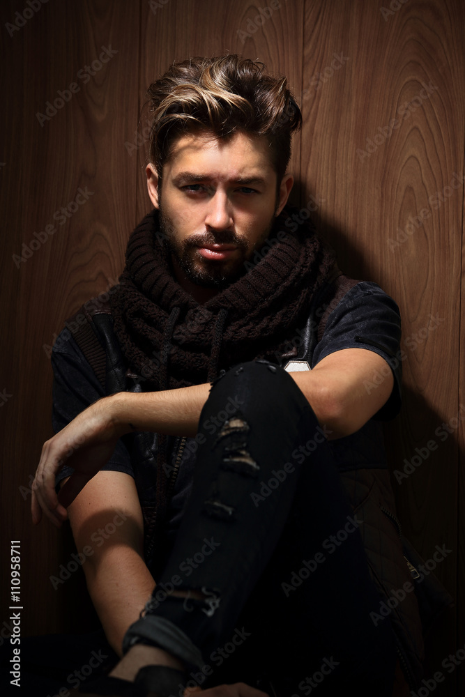 Fototapeta premium beautiful fashionable man against wooden wall