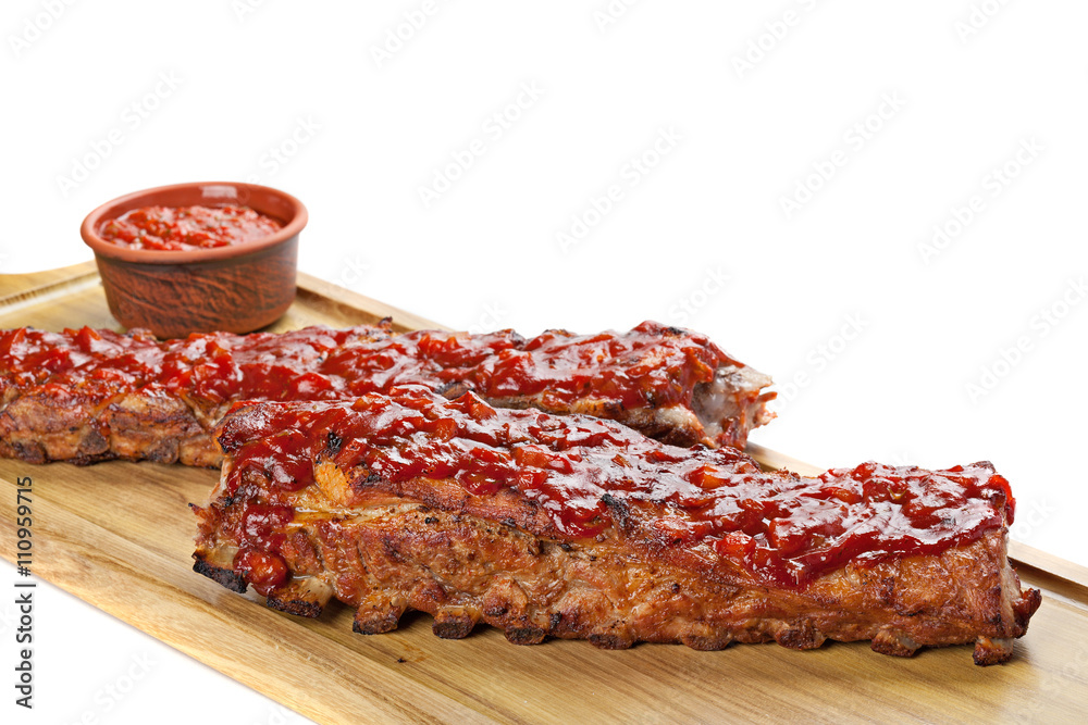 Obraz premium Barbecued ribs with sauce on cutting board.