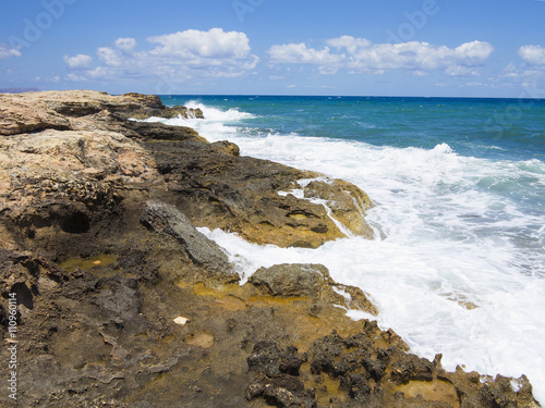 Big waves on rock coast blue sea and sky on Crete