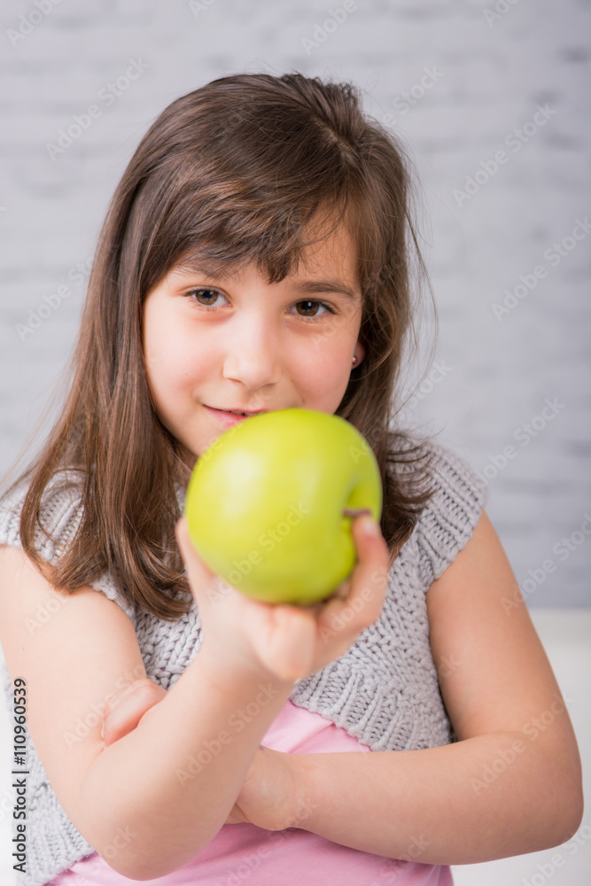 mädchen zeigt einen grünen apfel