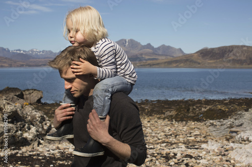 Father carrying son on shoulders, Loch Eishort, Isle of Skye, Hebrides, Scotland photo