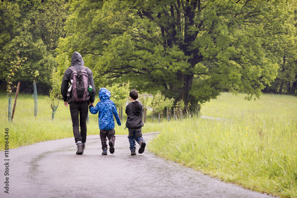 Fototapeta premium Father with children on rain spring walk