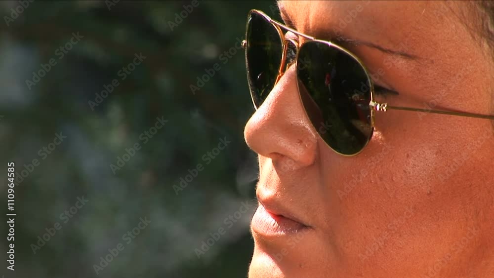 Young mid adult woman with sunglasses exhaling a cigarette smoke
Young mid adult woman with sunglasses exhaling a cigarette smoke