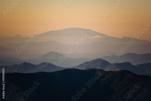 Sunset and foggy mountain valley landscape.