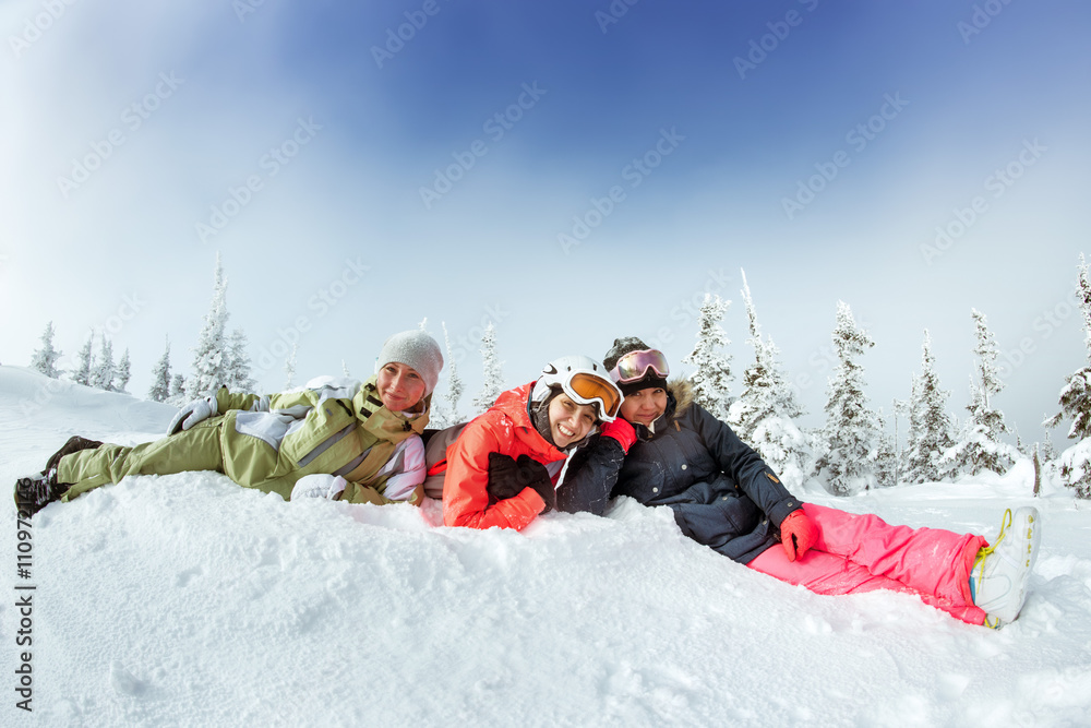 Group of three happy girls snowboarders lies in the snowdrift. Sheregesh resort, Siberia, Russia Group of three happy girls snowboarders lies in the snowdrift. Sheregesh resort, Siberia, Russia