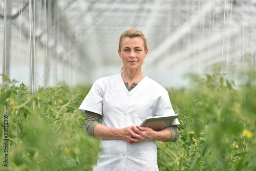 Portrait of agronomist standing in greenhouse