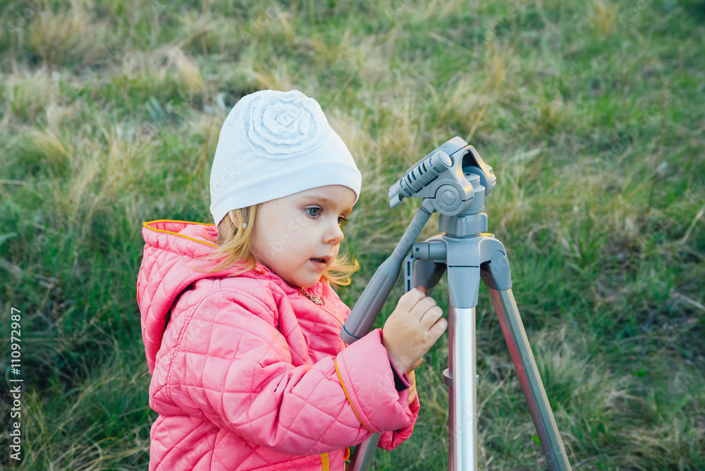 little girl on nature with a tripod