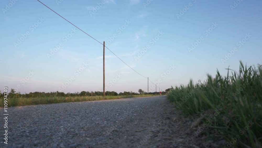 Man riding a bike on a dirt road at sunset Man riding a bike on a dirt road at sunset