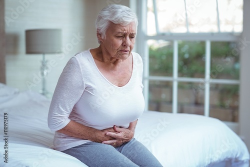Quadro su tela Senior woman suffering from stomach pain