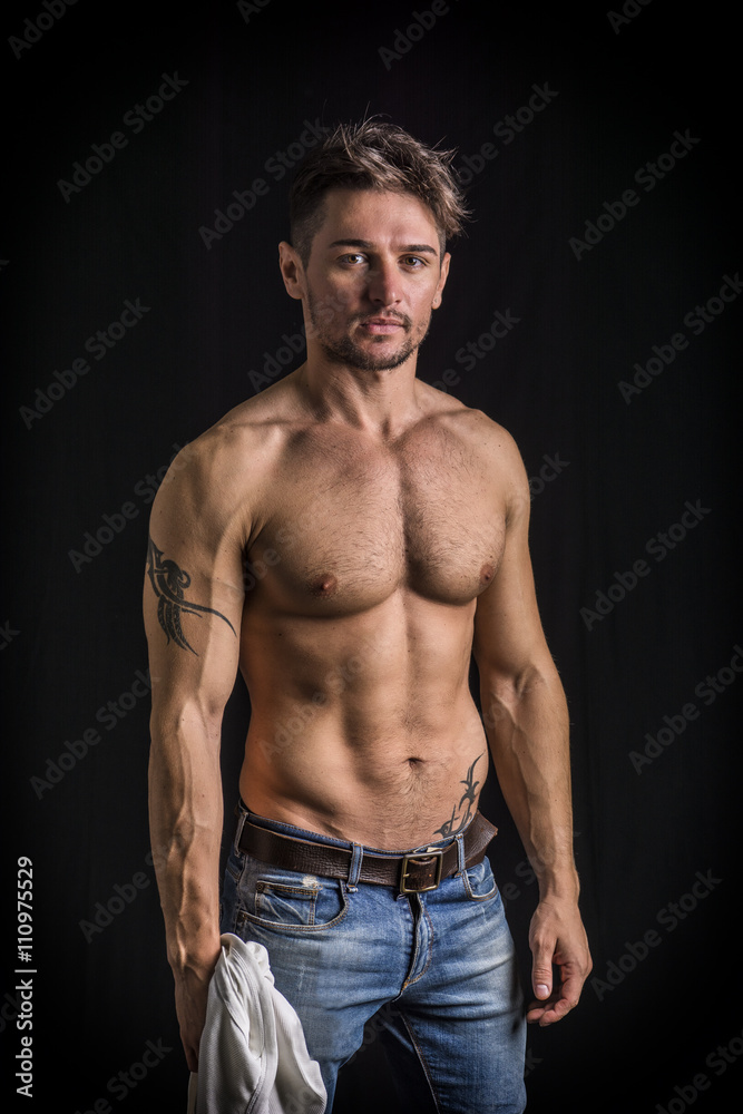 Attractive young man with naked muscular torso, wearing jeans Attractive young man with naked muscular torso, wearing jeans