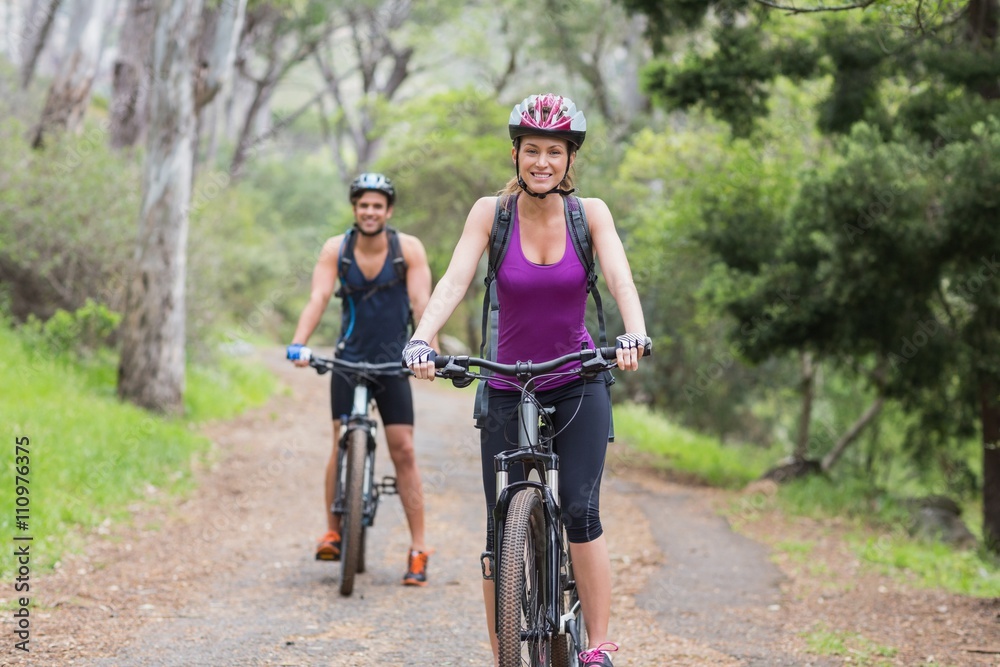 Portrait of man and woman riding bike in forest Portrait of man and woman riding bike in forest