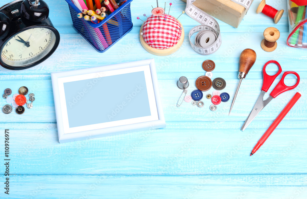 Photo frame tools tailor spools threads buttons needle sewing blue wooden background
Photo frame tools tailor spools threads buttons needle sewing blue wooden background