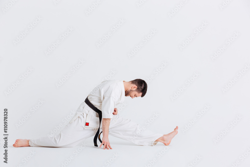 Man in kimono doing stretching exercises Man in kimono doing stretching exercises
