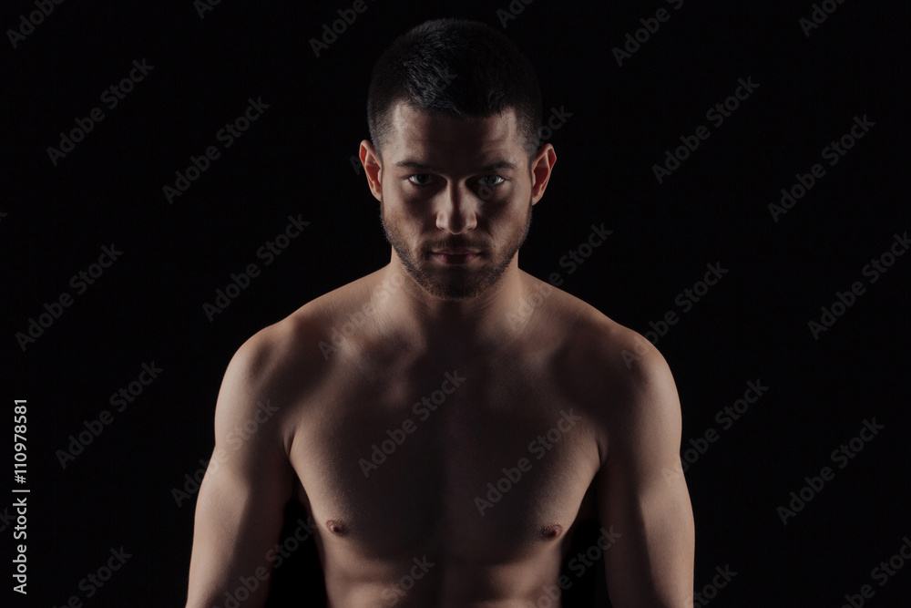 Naklejka premium Muscular man looking at camera