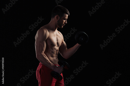 Muscular man workout with dumbbells © Drobot Dean