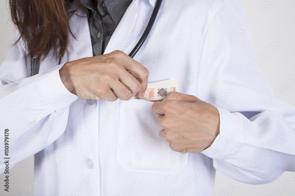 woman doctor hands with white gown and stethoscope tucking a wad of Euro banknotes in her pocket
