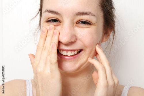 Nastolatka myje twarz na białym tle 