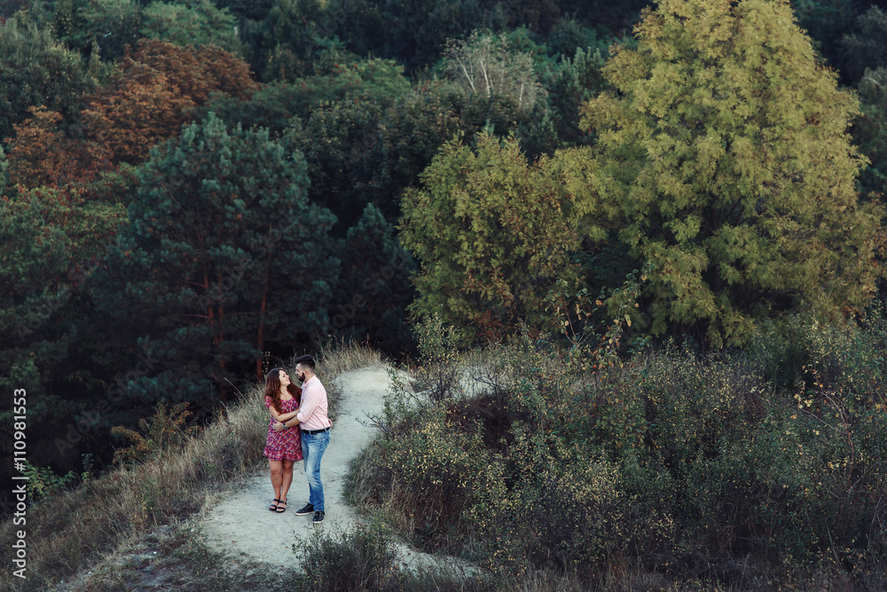Beautiful couple, husband & wife posing & hugging in forest, lan