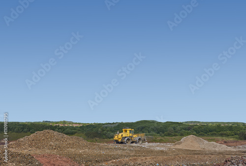 Digger burying waste on landfill site