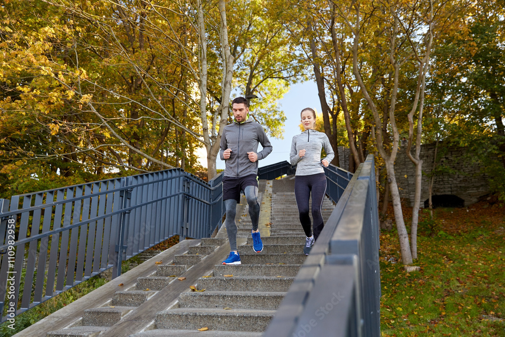 Fototapeta premium happy couple running downstairs in city