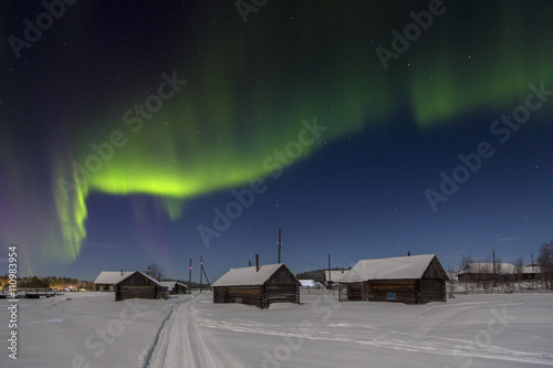 Fotografi Village house in the lights of moon and Aurora borealis