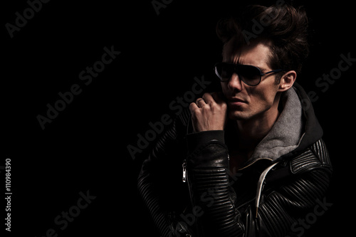 side view of a dramatic man in leather jacket and sunglasses