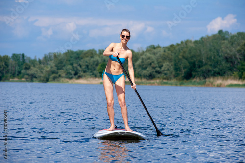 SUP Stand up paddle board woman paddle boarding03 © serguastock