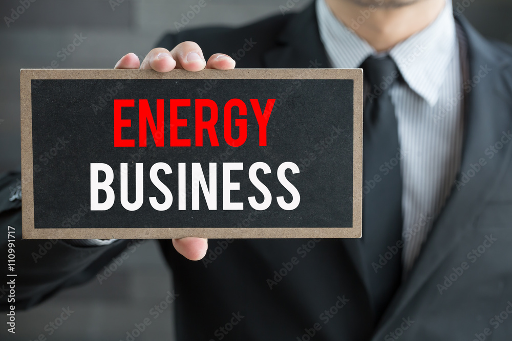 Energy business, message on blackboard and hold by businessman Energy business, message on blackboard and hold by businessman