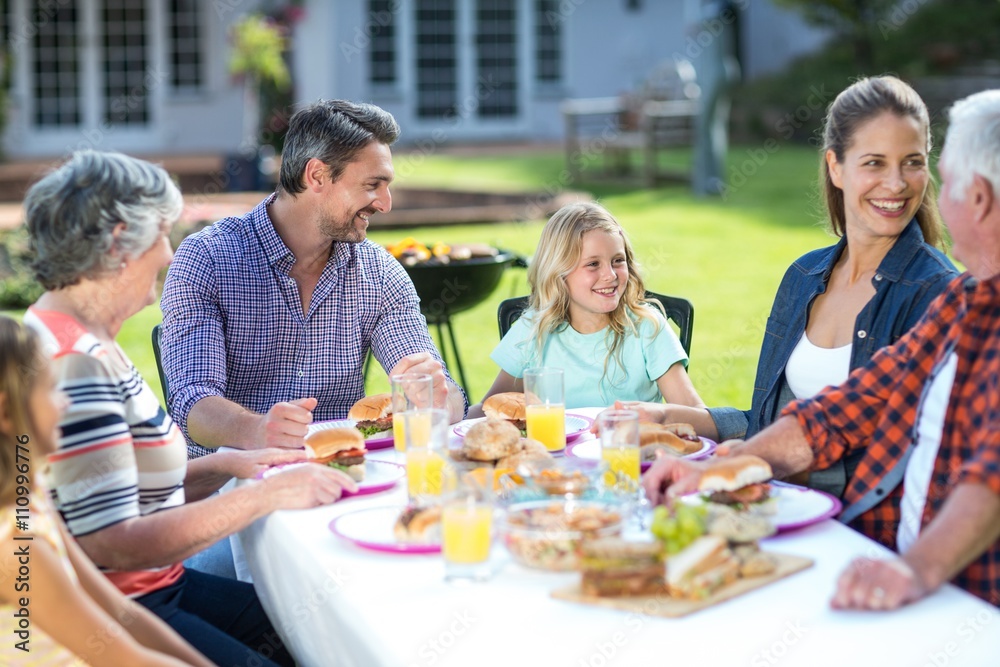 Happy multi-generation family sitting at table Happy multi-generation family sitting at table