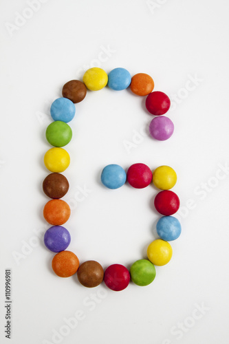 La lettera G formata da coloratissimi confetti di cioccolato.