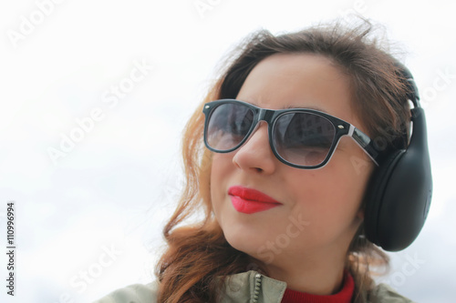 woman with headphones in park autumn