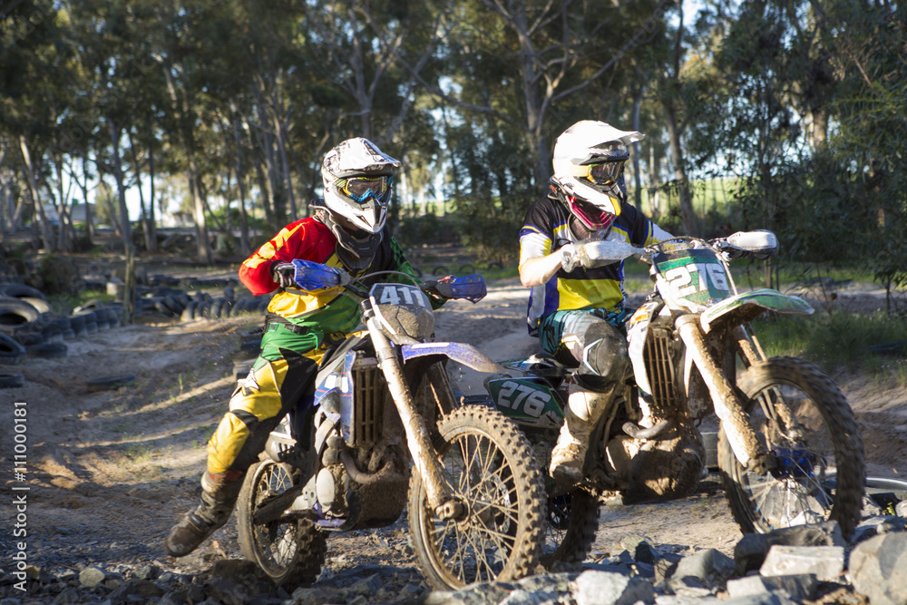 Two young male motocross riders in forest Two young male motocross riders in forest
