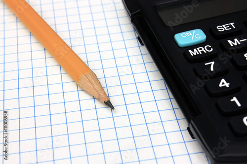 Calculator with pencil on notebook photo