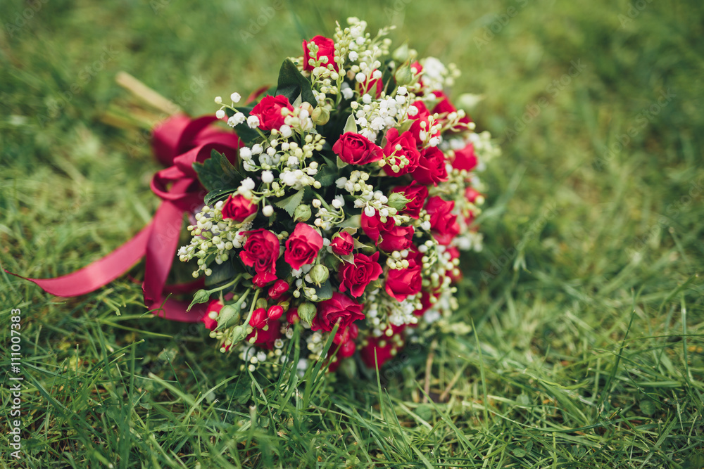 Bouquet of beautiful flowers and greenery is on the green grass