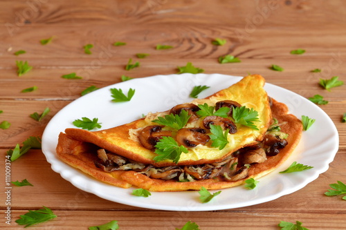 A delicious omelet with mushrooms, cheese and parsley. Stuffed omelet. Eggs recipe