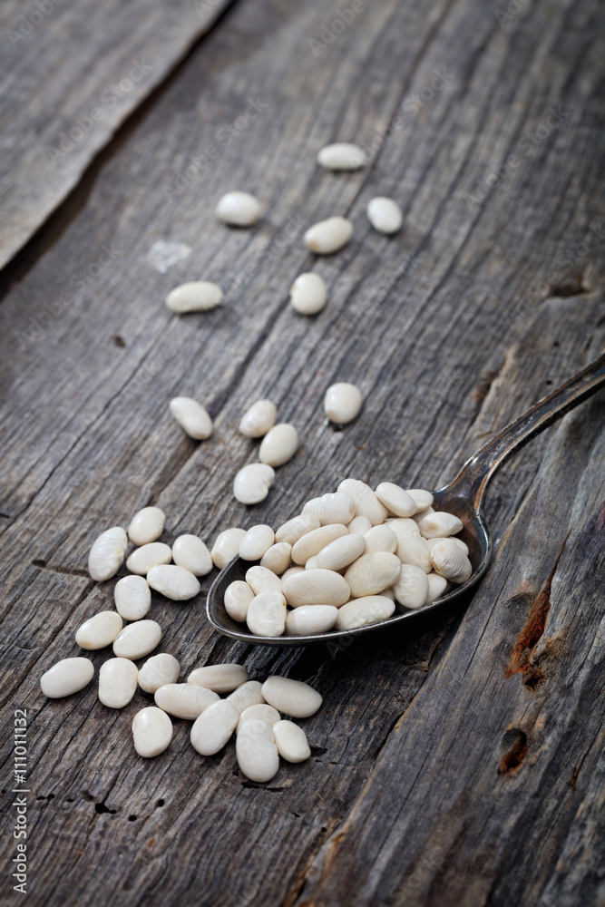Beans on spoon, on wooden surface. Beans on spoon, on wooden surface.