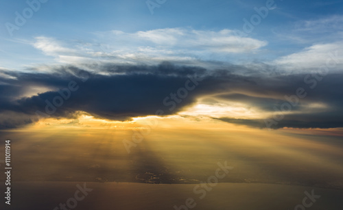 light beam of sunlight through clouds above sunset sky