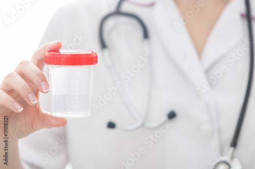 Nurse holds test container in her hand.